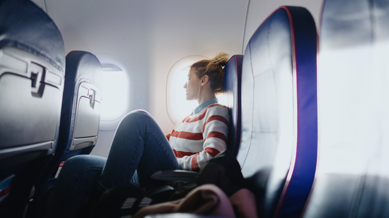 Woman looking out the window inside a plane