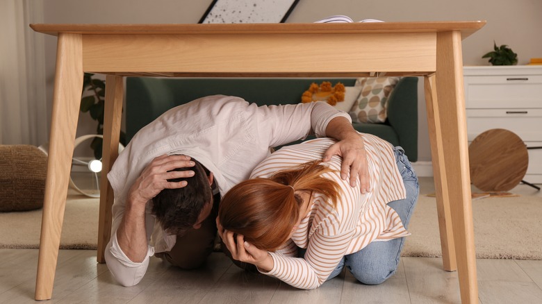 Couple under table during earthquake