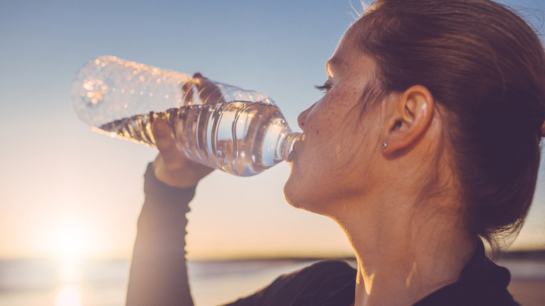 woman drinking bottled water