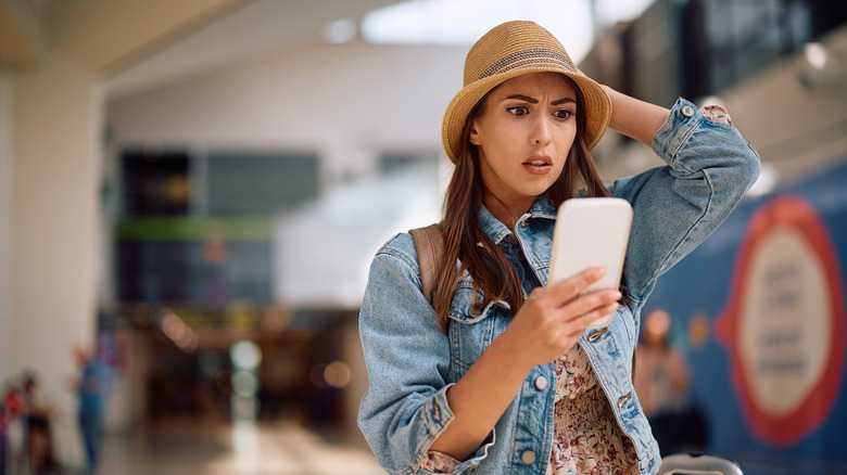 Person getting an unpleasant phone notification at the airport