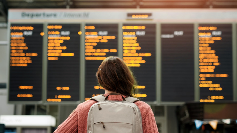 Person looking at departure screen at airport