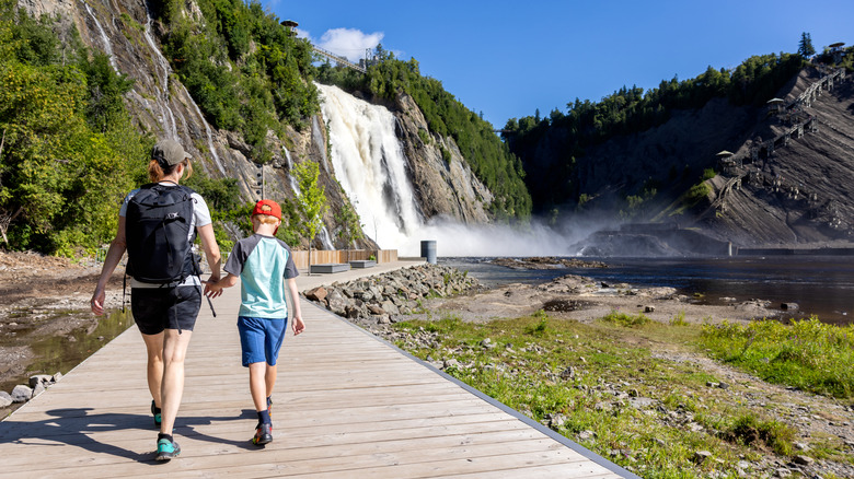 A mother and son walk in Montmorency Falls