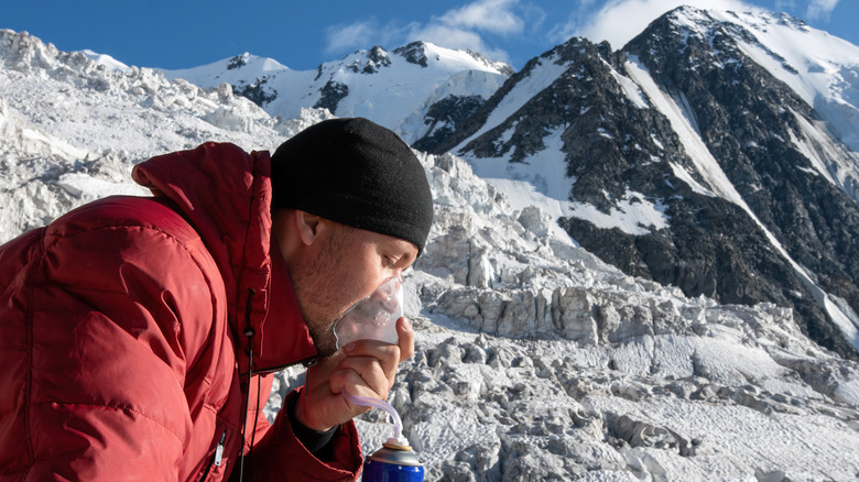 Hiker on snowy mountain with oxygen
