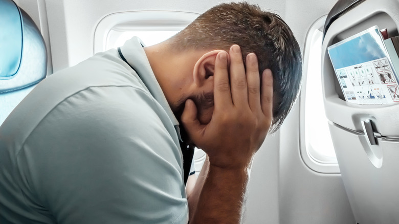 Man feeling ill on airplane
