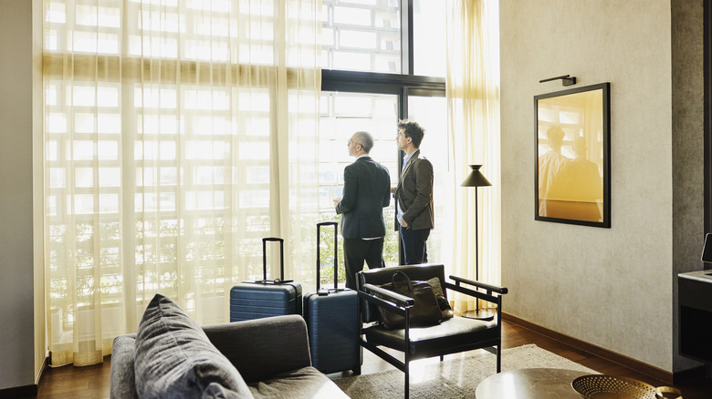 Two men looking out of hotel room window