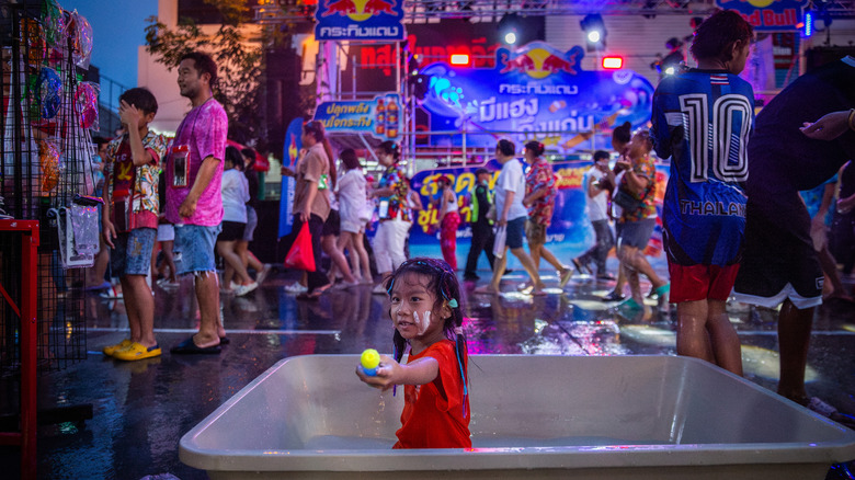 Child plays in the water during Songkran festival in Thailand