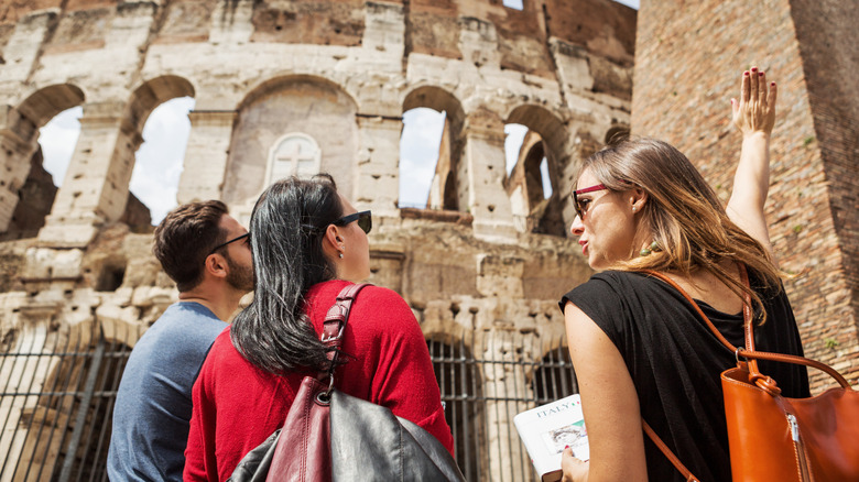 Tour guide shows travelers the Colosseum