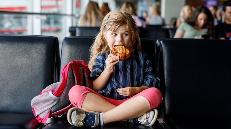 Kid eating pastry in airport