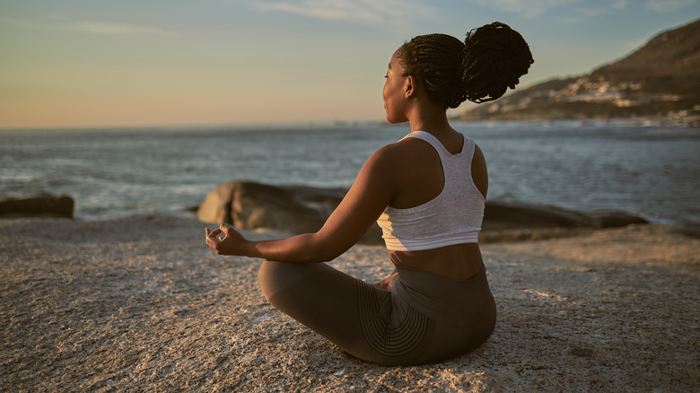 Woman meditating on beach