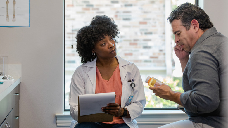 Doctor writing prescription for patient