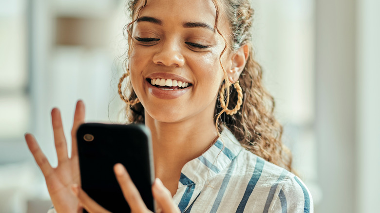 Smiling woman using phone
