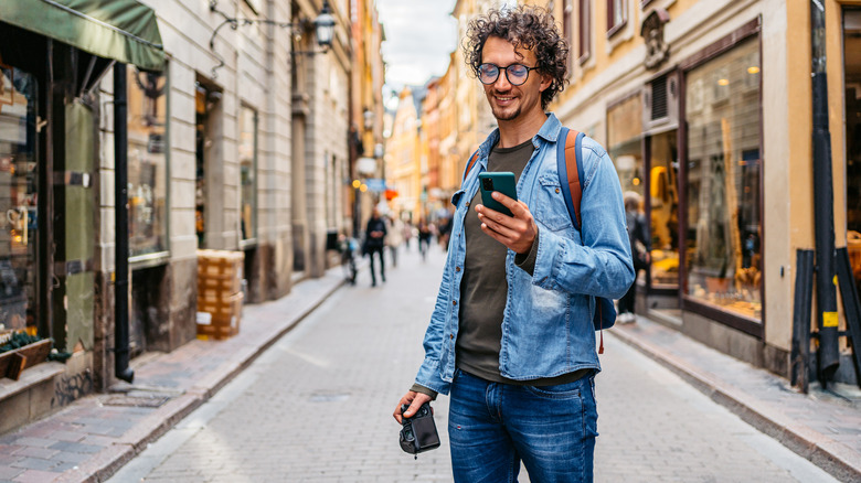 A solo traveler exploring Sweden looking at a phone