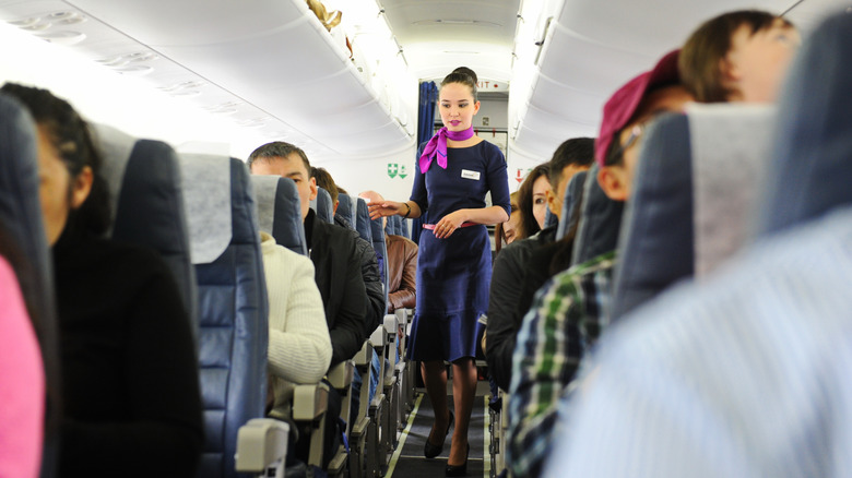 A flight attendant checking on passengers