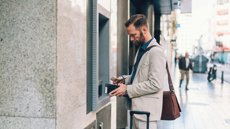 Traveler withdrawing money from ATM