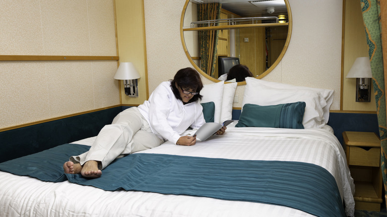 Woman reading on cruise ship bed