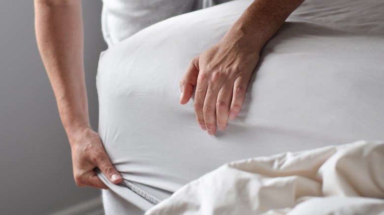 Person stripping bed sheets