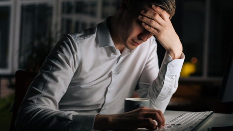 Stressed man overwhelmed at work