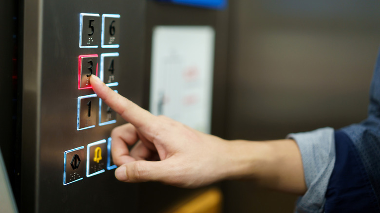 Person pressing an elevator button