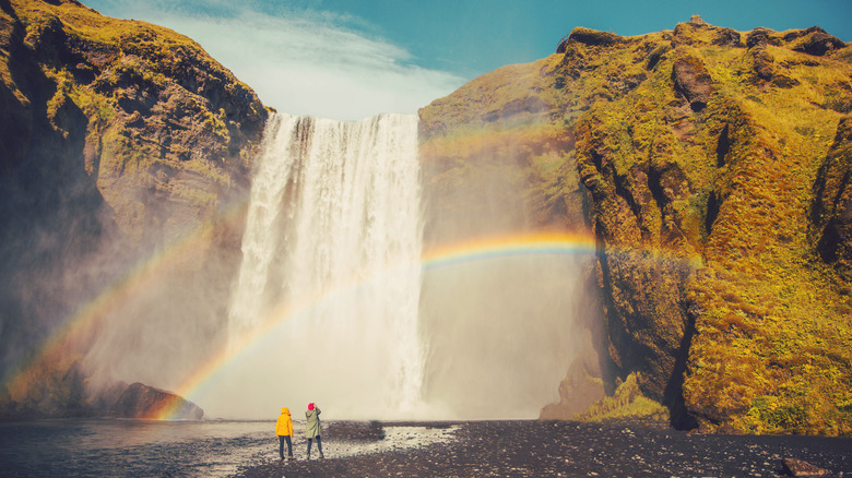 a couple admires iceland waterfall