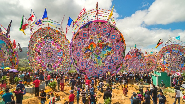 Cemetery with crowd and large circular kites.