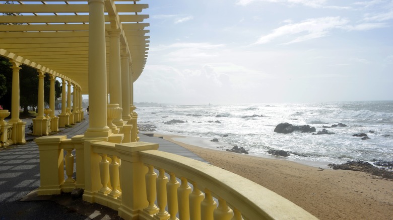 A yellow bannister of a pergola facing the sea