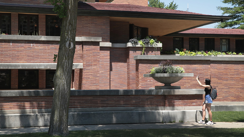 Woman taking a photo of Frank Lloyd Wright's Robie House