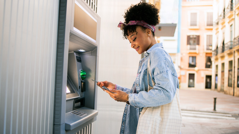 smiling woman using an outdoor ATM