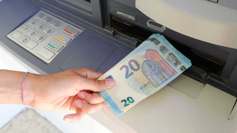 Person withdrawing euros from an ATM