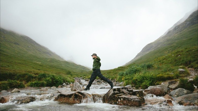 man hiking Scottish river