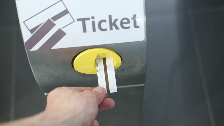 Person entering their ticket in the Paris Metro