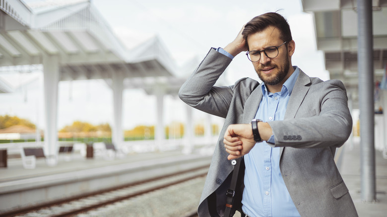 Man looking at his watch at the train station