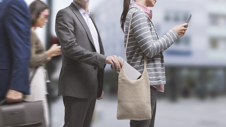 Man pickpocketing woman on street