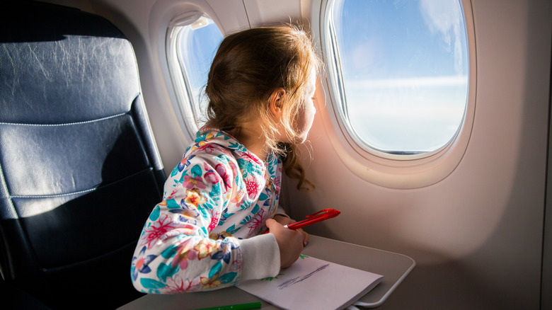 Girl coloring on plane