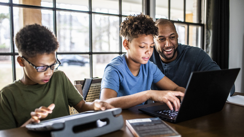 Father and sons using computers