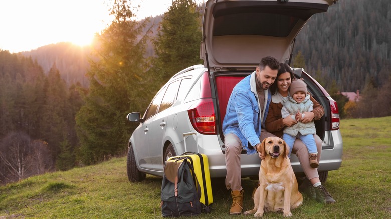 family sitting in car trunk