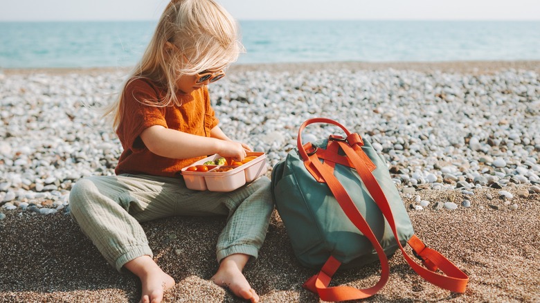 Girl eating snack on beach