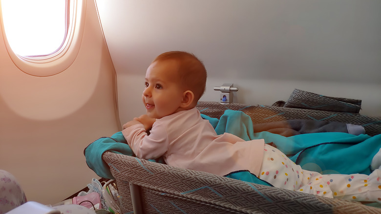 Baby in bassinet on plane