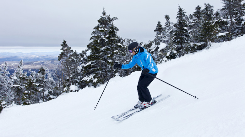 A blue-clad skier tears down the slopes