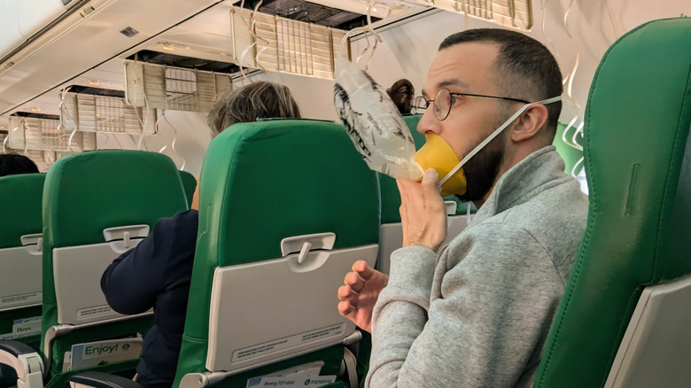 A plane passenger using an oxygen mask