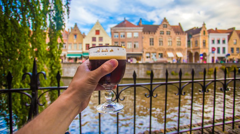 Man holding dark beer in Bruges, Belgium