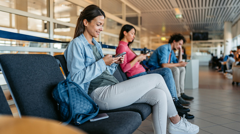 People using phones at airport