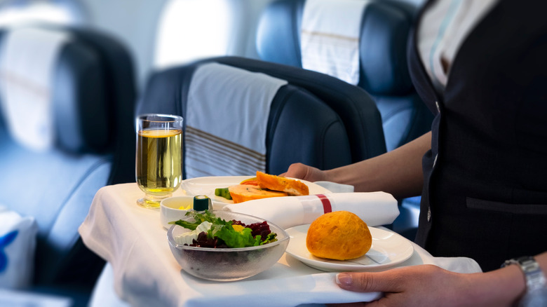 A flight attendant serving a meal