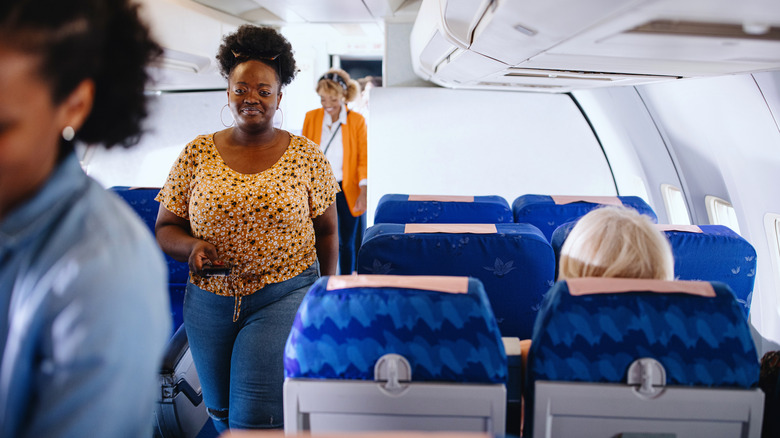 Passengers finding seats on a plane