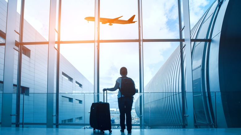 Person at airport watching plane