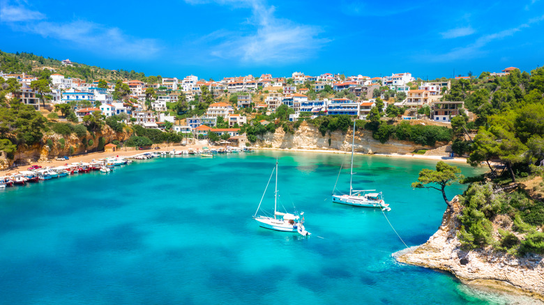 Turquoise bay with background hill village in Alonissos, Greece