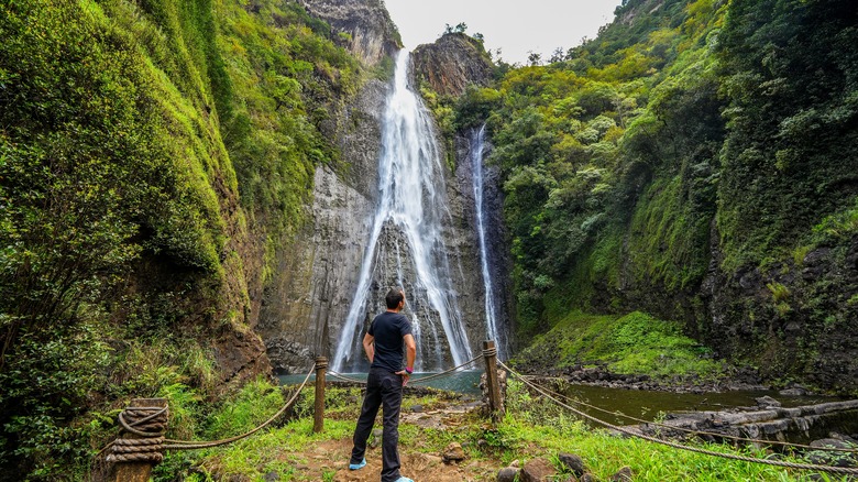 Man standing in front of Manawaiopuna Falls
