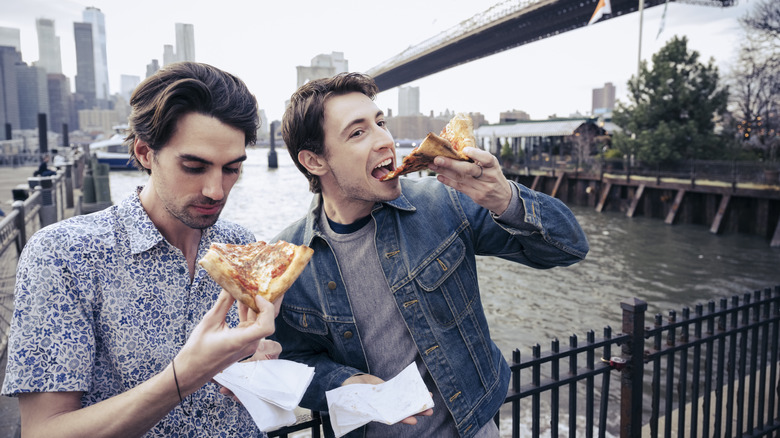 Two men eating pizza in New York