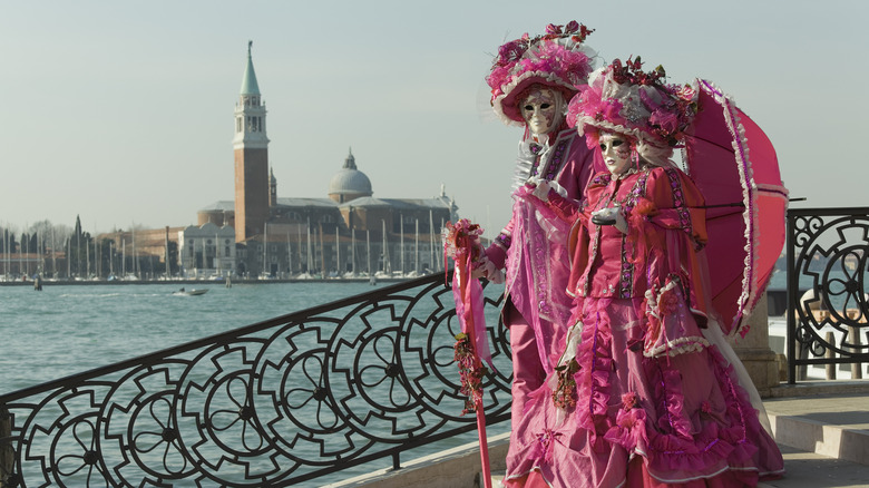 A pair of masked pink costume carnival attendees in Venice, Italy