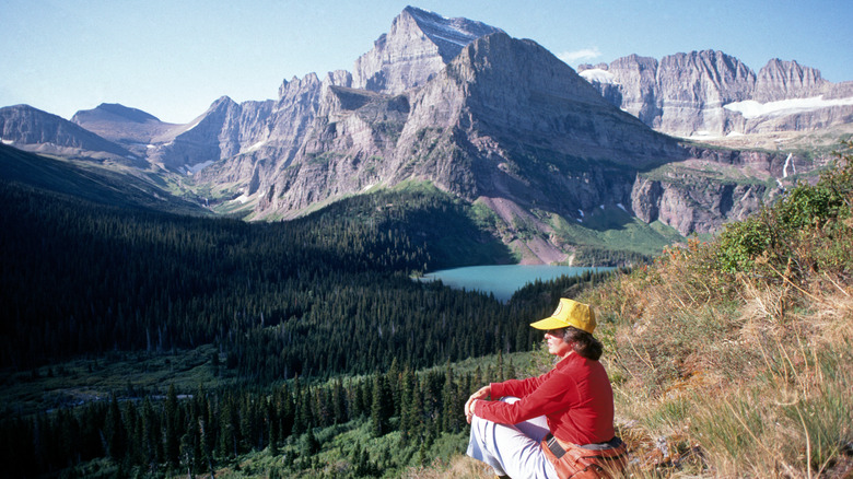 hiker rests near grinnell glacier trail in Montana