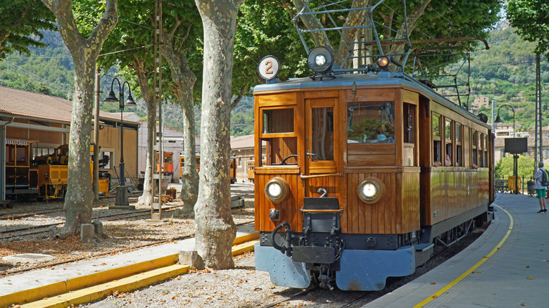 A wooden antique train pulls into the station of Soller, Mallorca